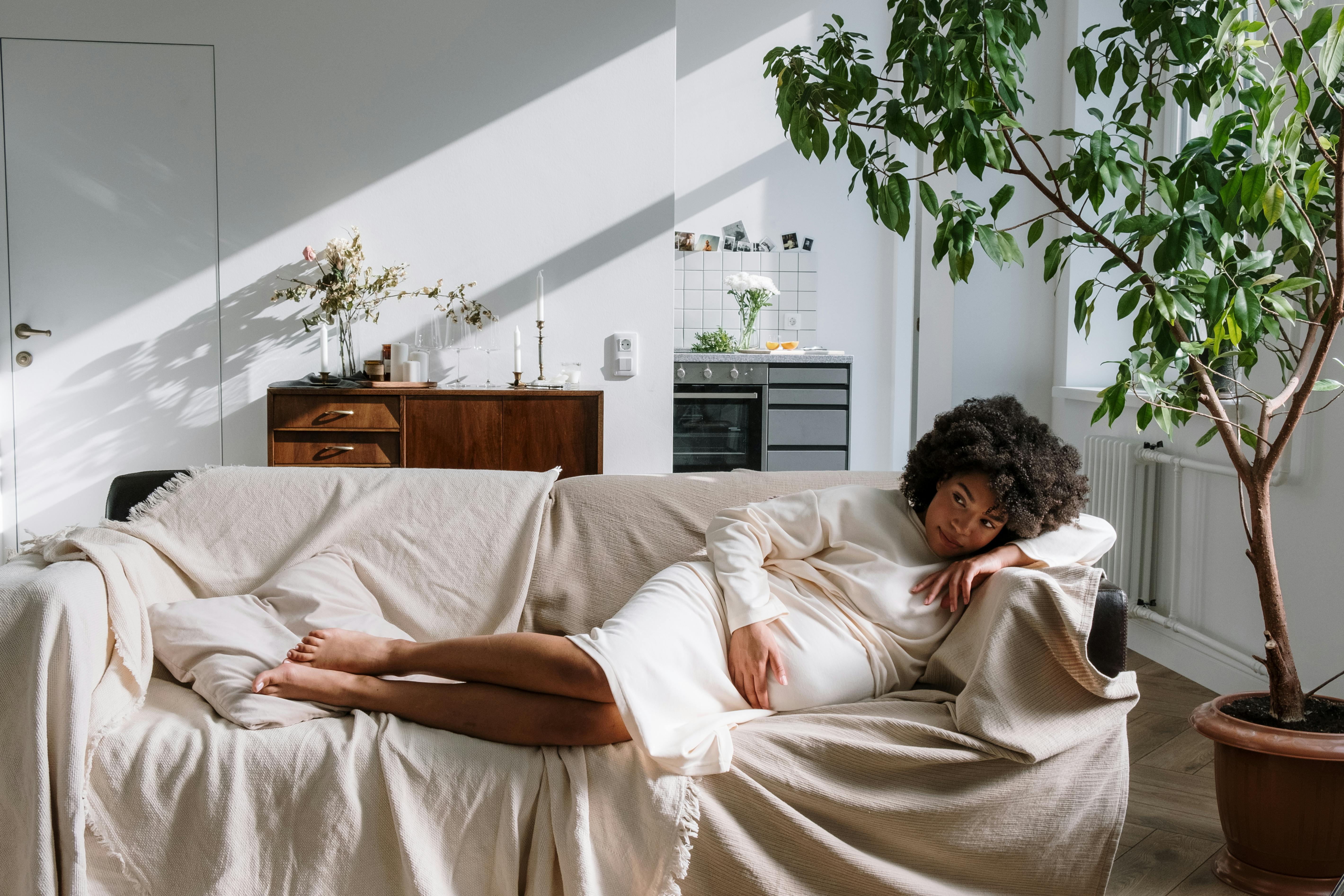 woman lying on bed covered with blanket