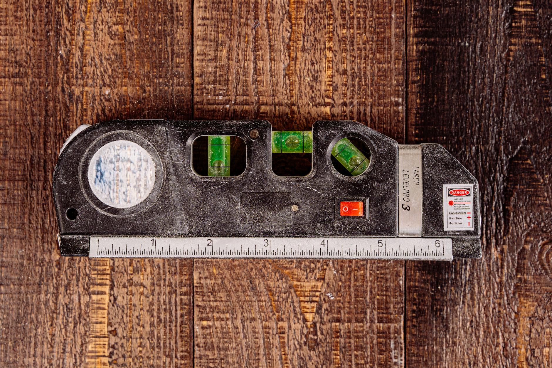 Torpedo Level Tool On A Workbench With Shelves And Artwork In The Background