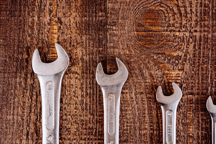 Metal Wrenches On Wooden Table