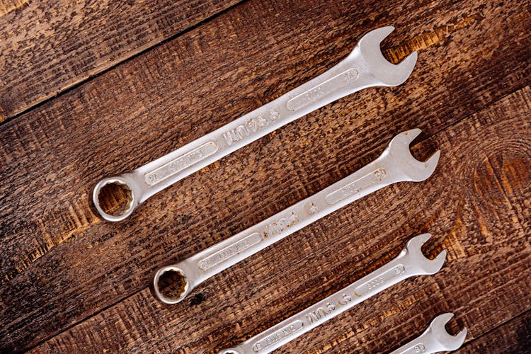 Metal Wrenches On Wooden Table