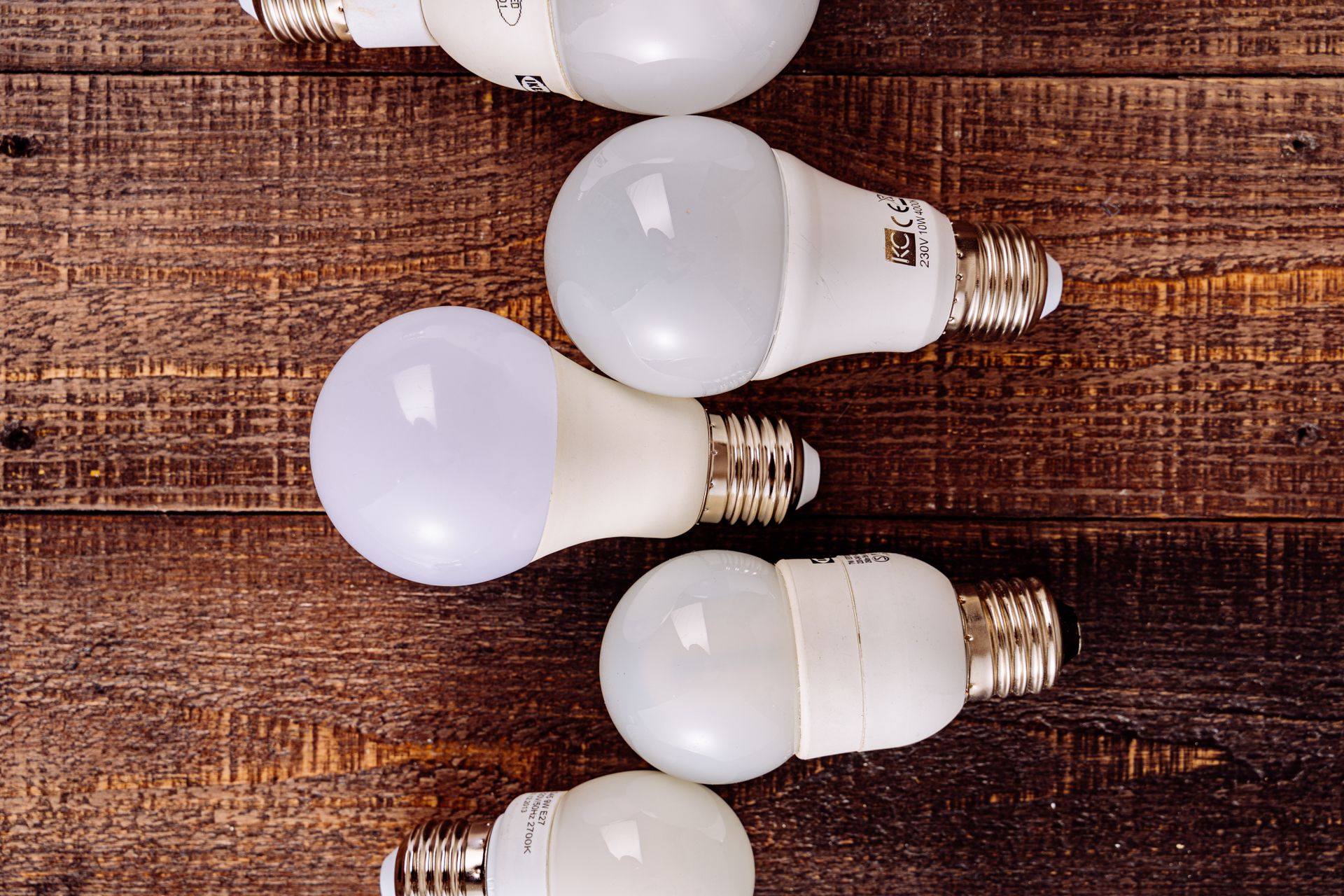 Collection of LED light bulbs arranged on a rustic wooden background.