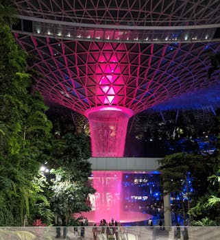 Stunning view of Jewel Changi Airport's indoor waterfall illuminated at night.