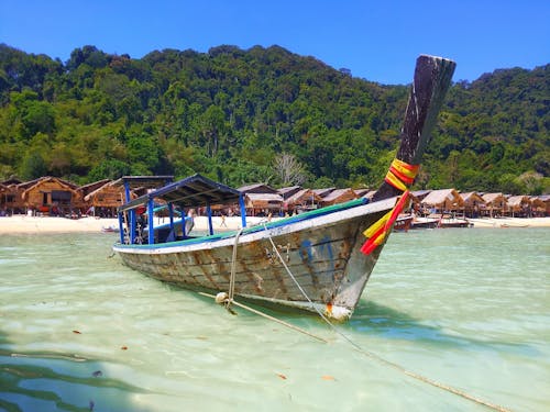 Wooden Boat Docked on the Shallow Water of the Beach