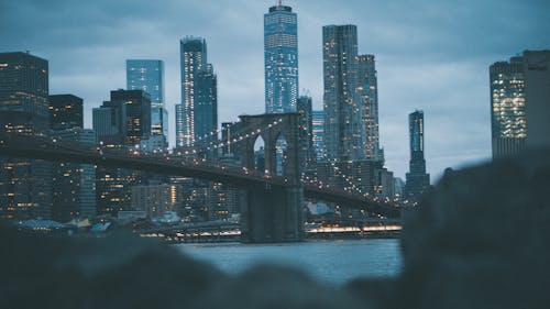 City Skyline Across Brooklyn Bridge during Night Time