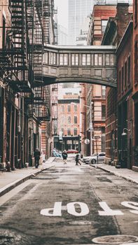 A classic New York street showcasing a historic skybridge and urban architecture.