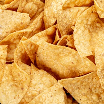 A detailed shot of golden, crispy tortilla chips, perfect for snacking or appetizers.