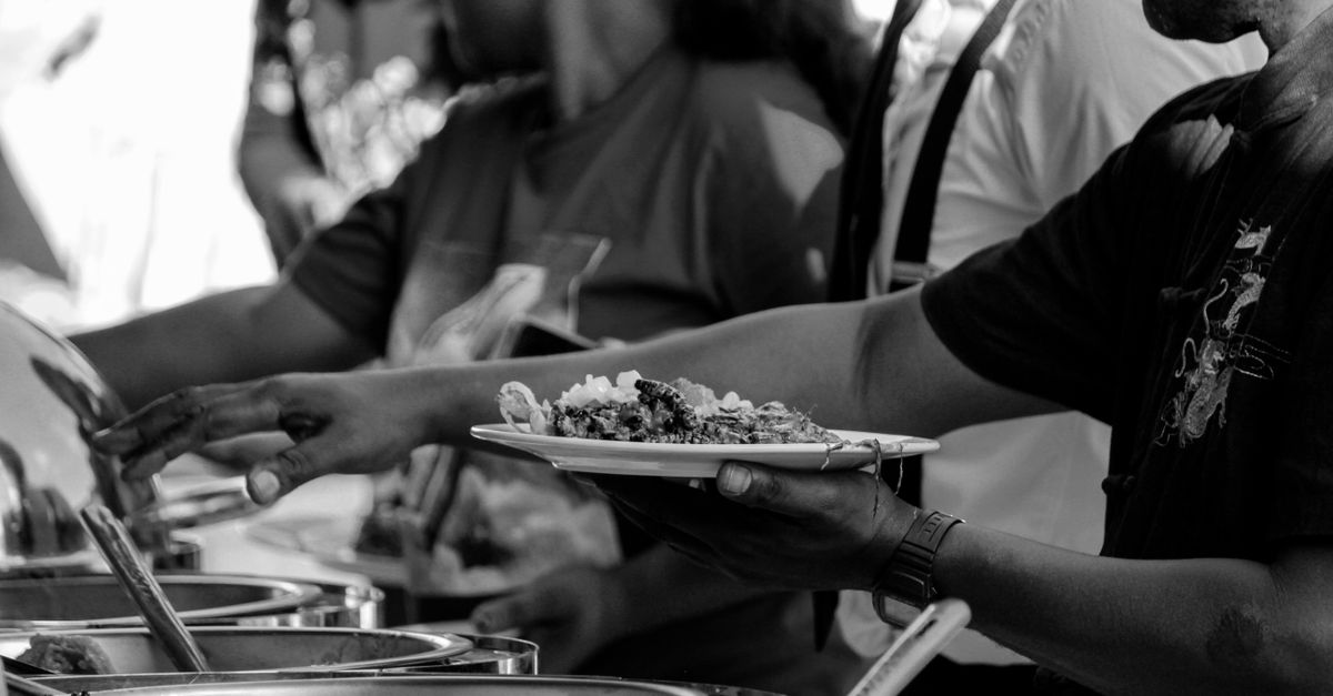 hands serving food at community outreach event