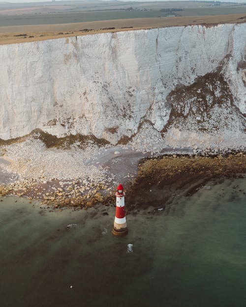 Lighthouse in sea near cliff