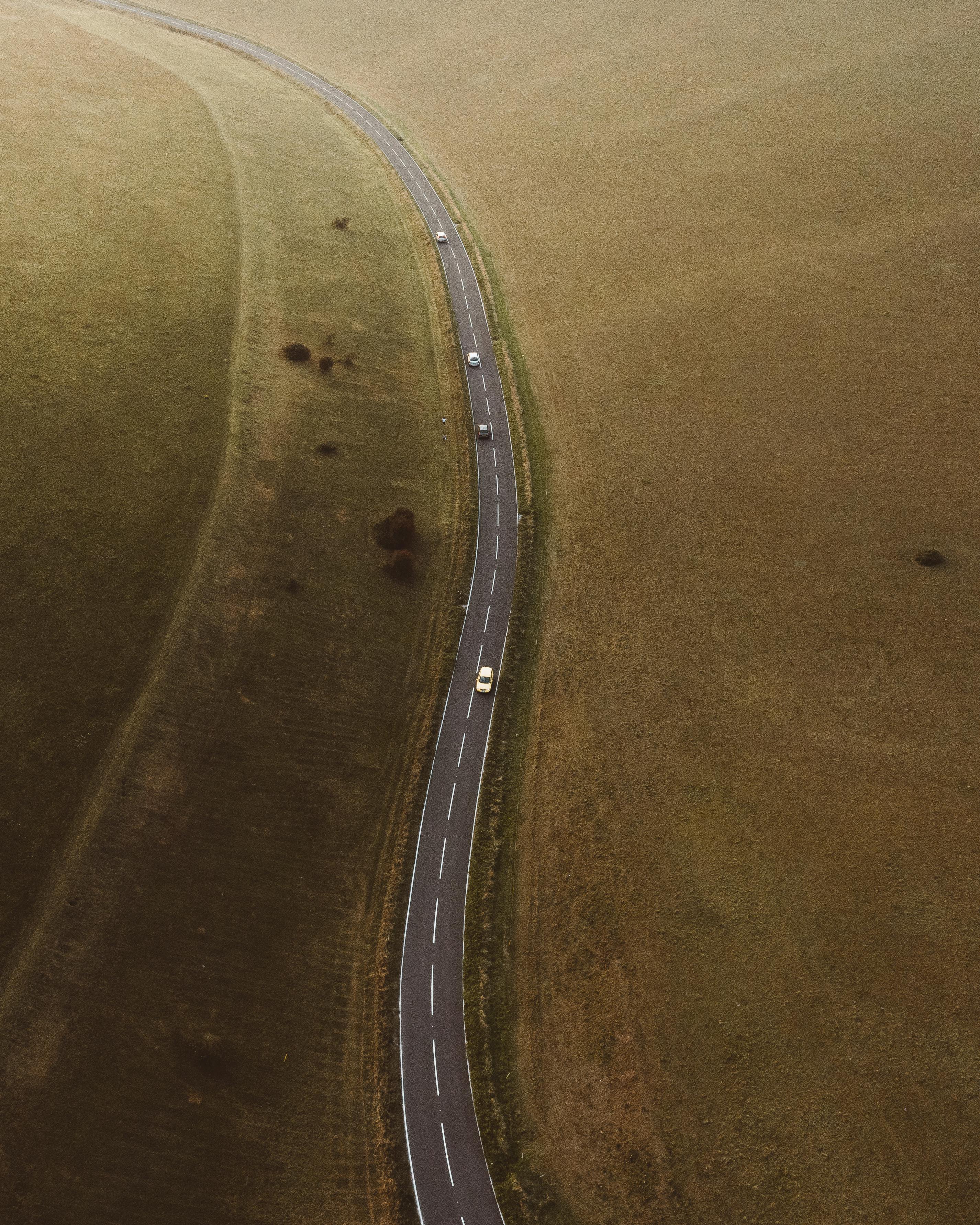 asphalt highway between grassy fields