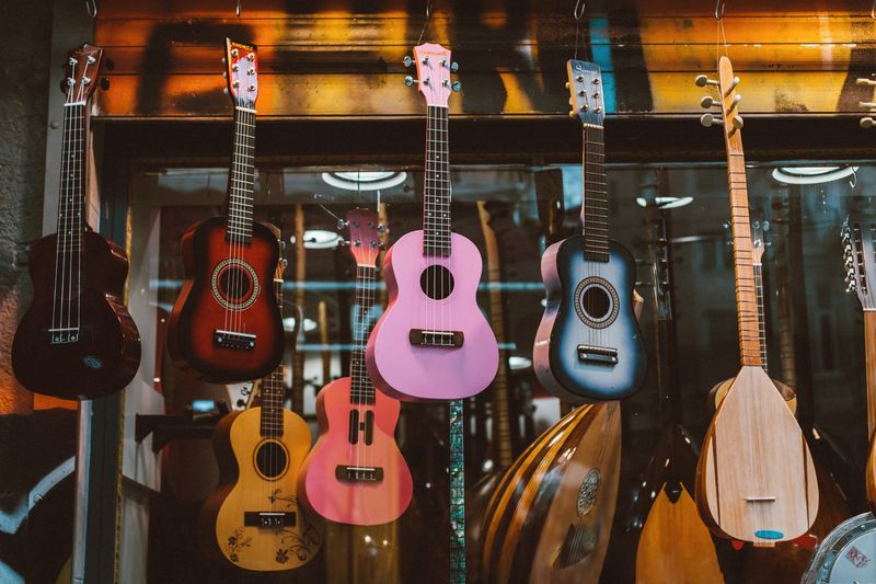 A colorful collection of ukuleles and mandolins hanging in a music store display, enhancing musical ambiance.