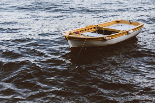 Free An Empty Wooden Boat Sailing on the Sea Stock Photo