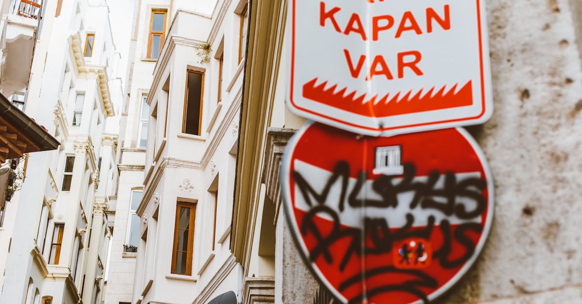 Urban scene featuring Turkish warning sign with graffiti against historic building facades.