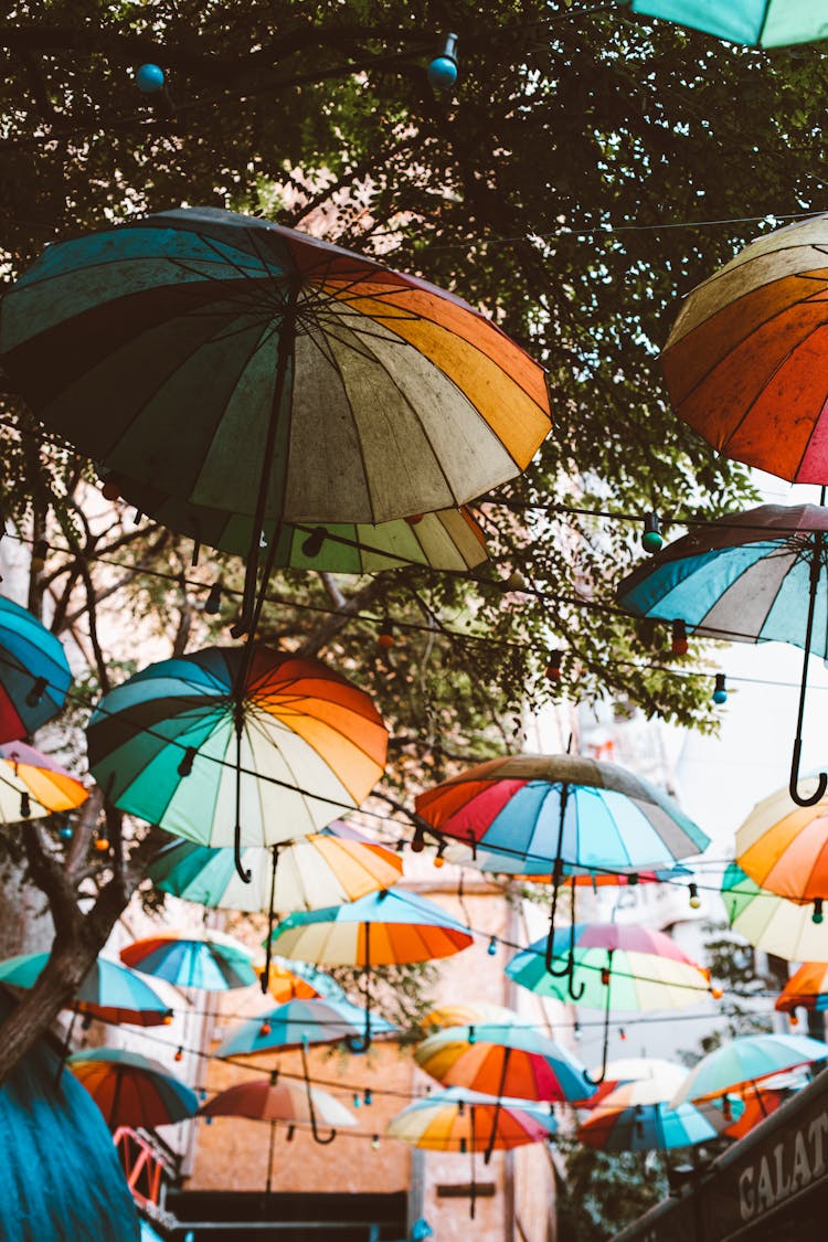 Colorful Umbrellas Handing On Strings Above A City Street