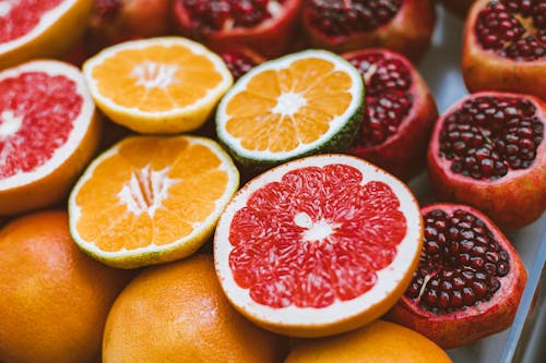 Fresh Cut in Half Oranges, Pomegranates and Grapefruits 