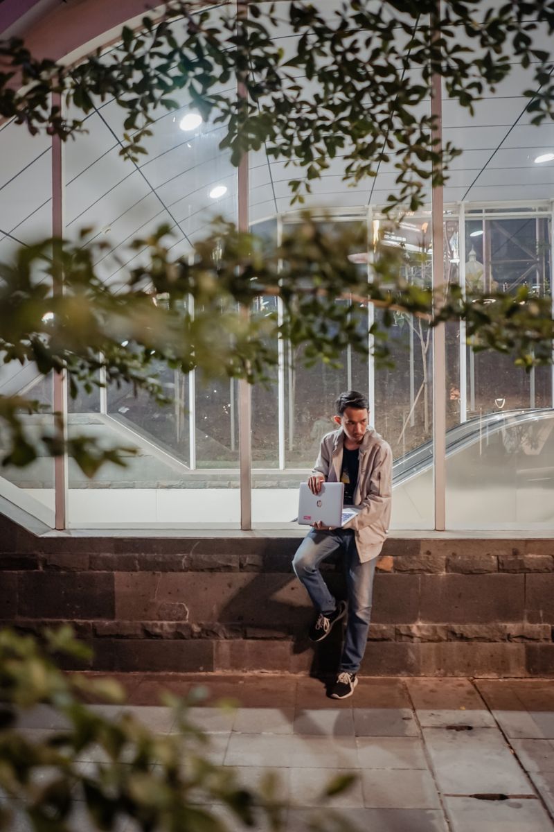 Person working on a laptop outdoors at dusk — photo by Irfan Zaky on Pexels