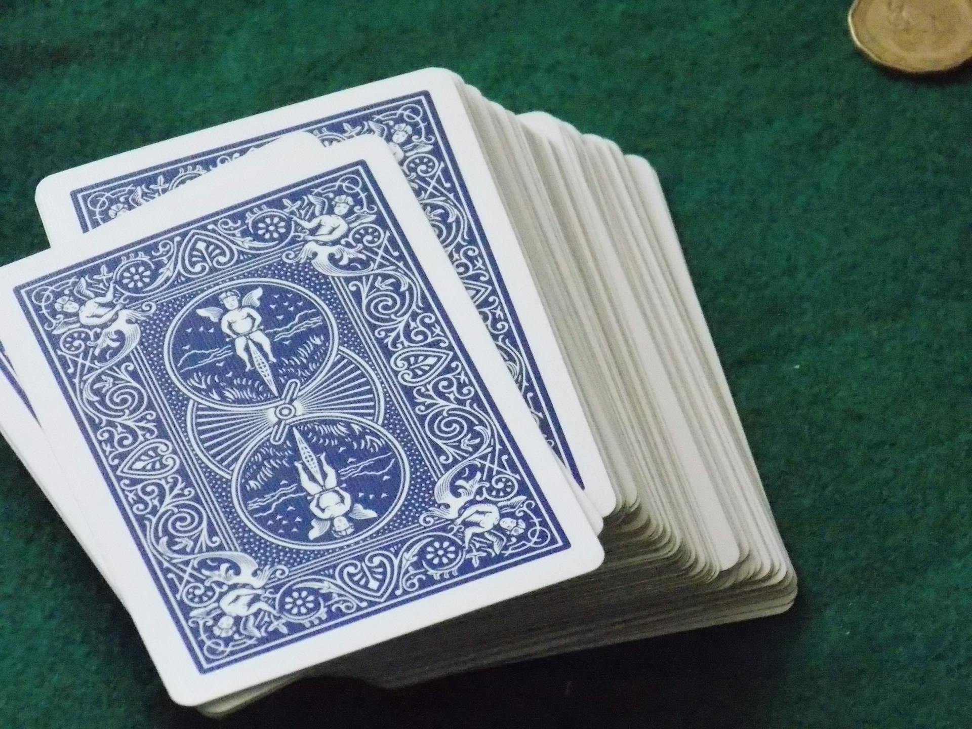 Image of a deck of playing cards stacked on a green felt table, suitable for gambling or game themes.