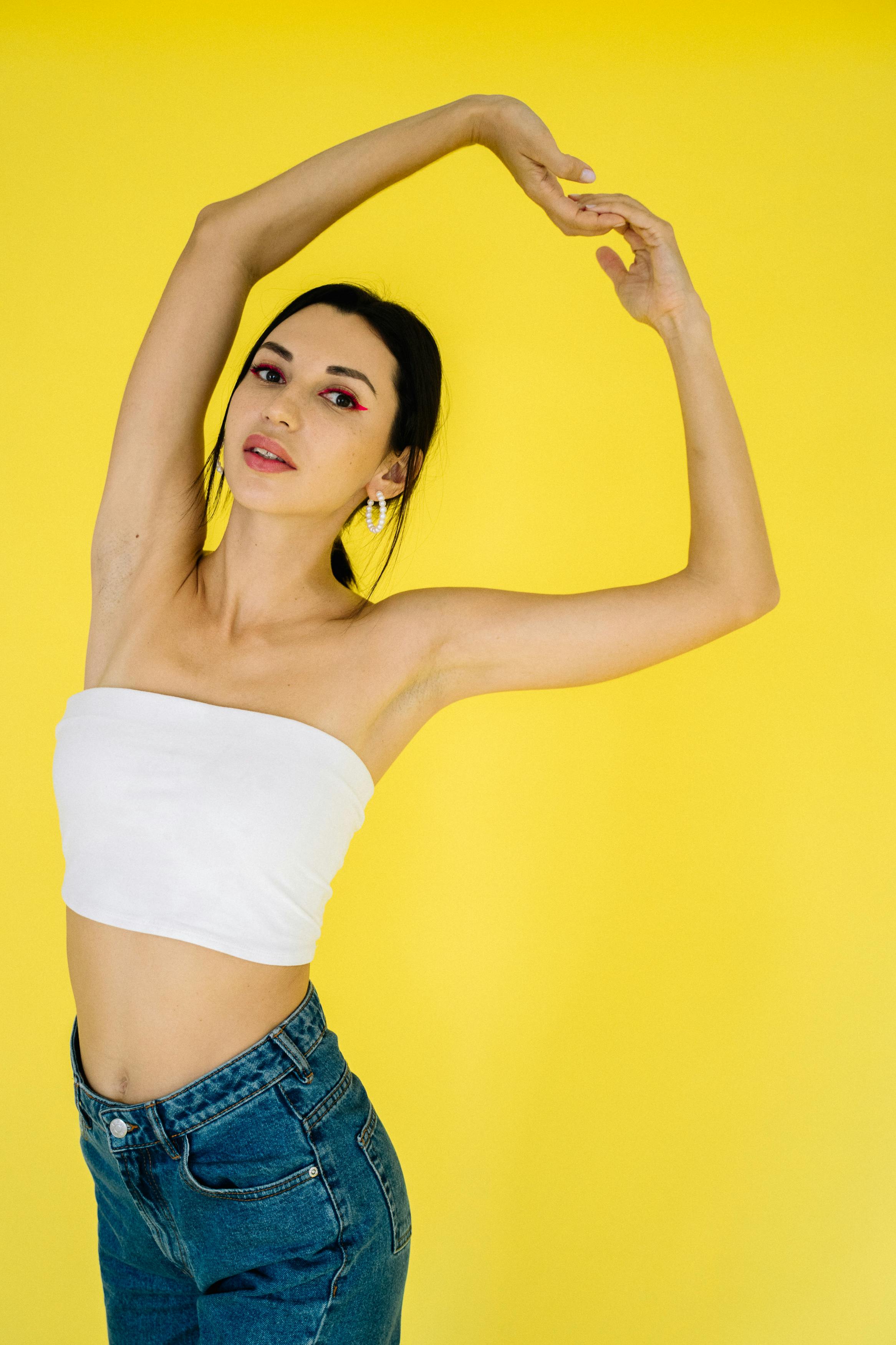 a woman in white tube top with arms raised