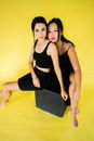 Women in Black Clothes Sitting on a Black Box