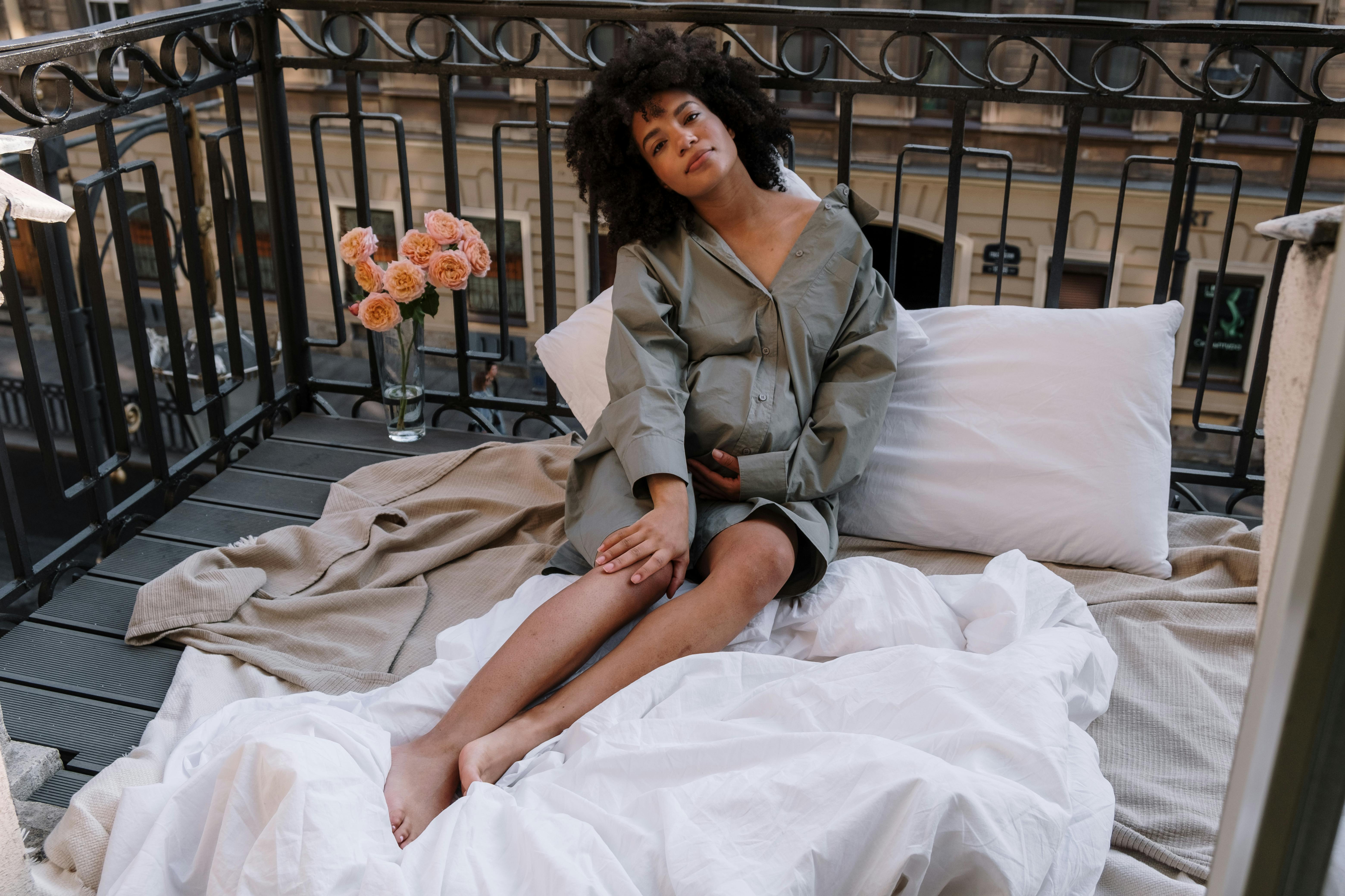 woman in brown coat sitting on bed