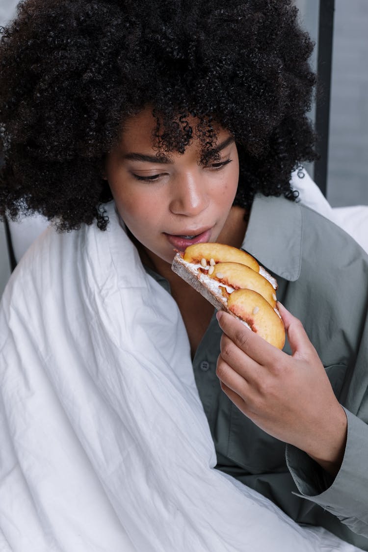 Young Woman Eating A Breakfast In Bed