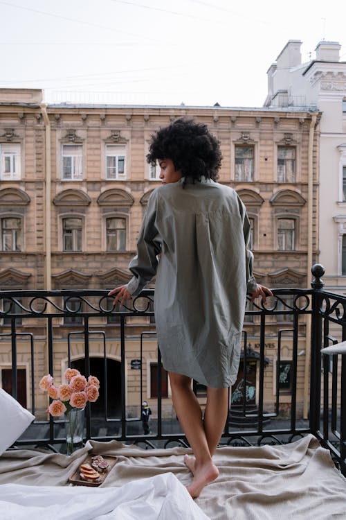 Woman in Gray Long Sleeves Standing on the Balcony