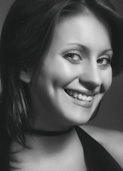 Grayscale Photo of a Woman While Smiling 
