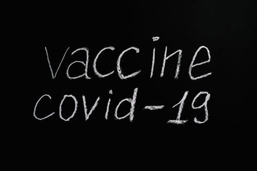Free Vaccine Covid-19 Lettering Text on Black Background Stock Photo