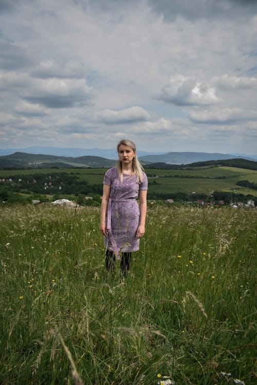 Blonde Woman in Violet Dress Standing in Fields