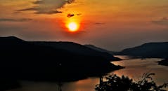 山间湖泊上，日落景色令人惊叹，色彩鲜艳，倒映在水面上