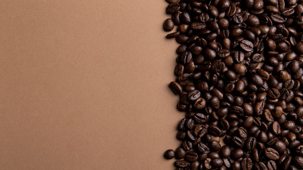 Freshly roasted specialty grade coffee beans resting on a burlap sack