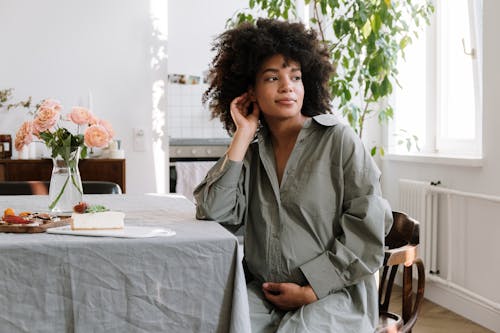 Pregnant Woman in Gray Long Sleeves Sitting on a Chair while Looking Afar