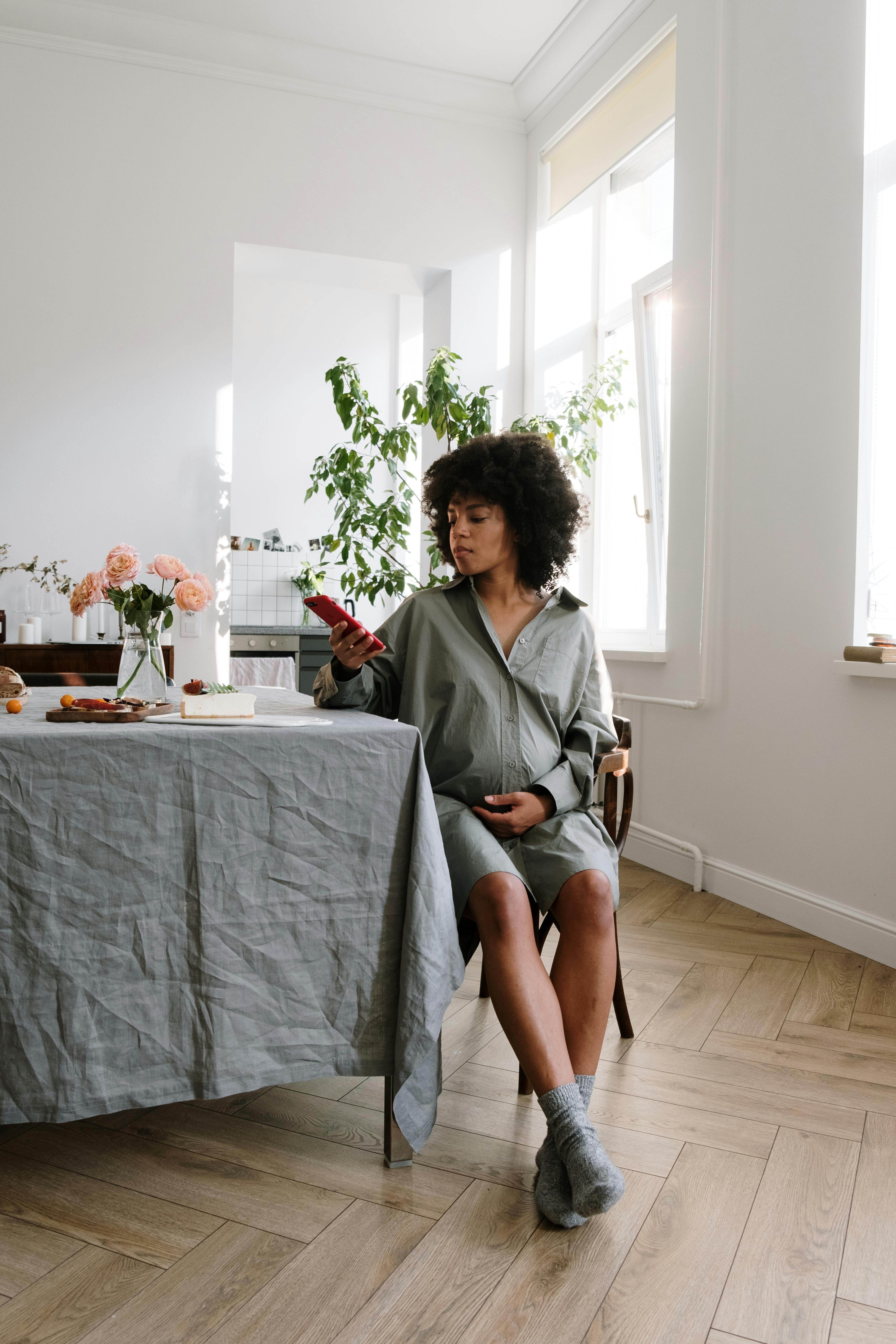 woman in gray long sleeve shirt sitting on gray sofa chair