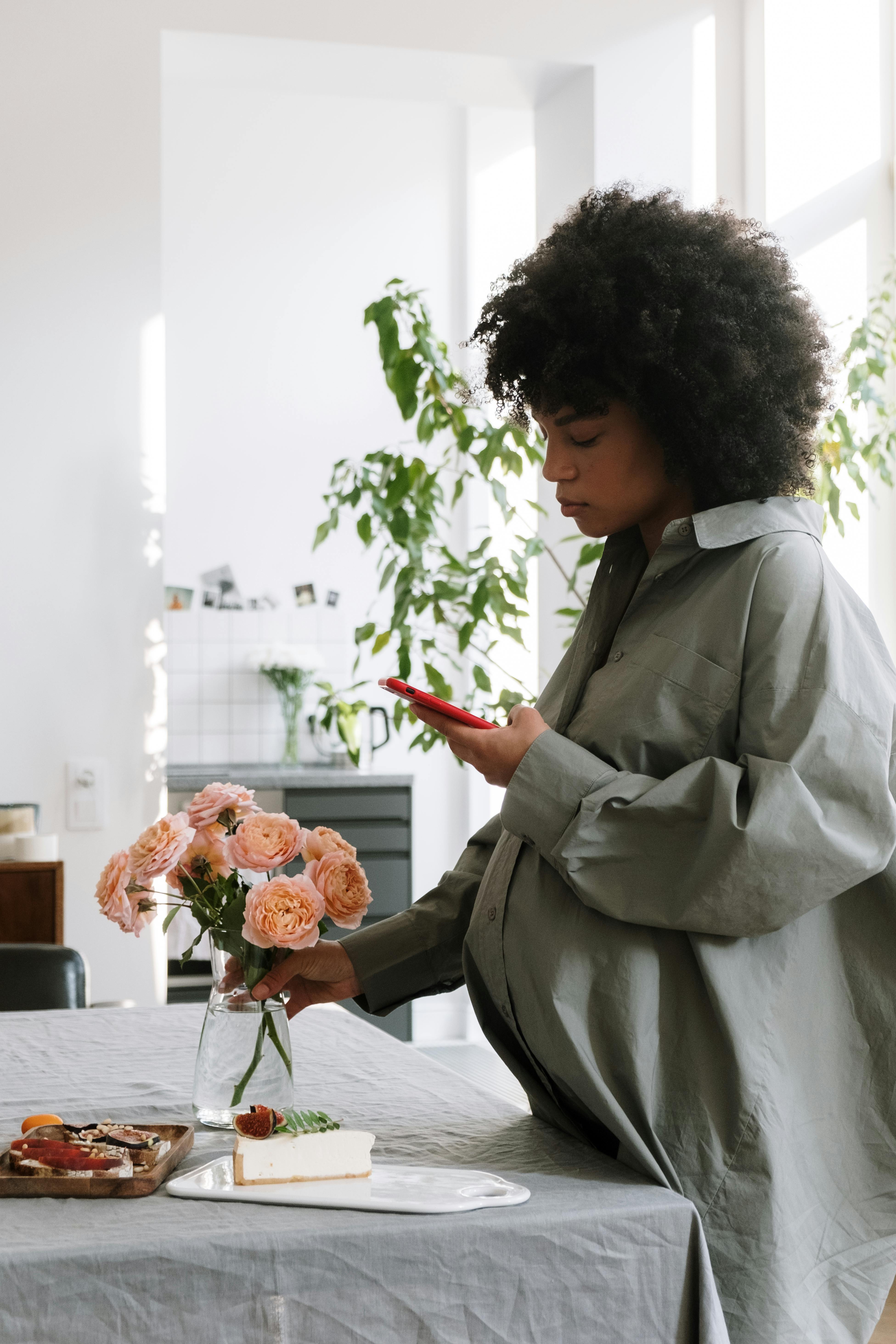 woman in gray coat holding bouquet of flowers