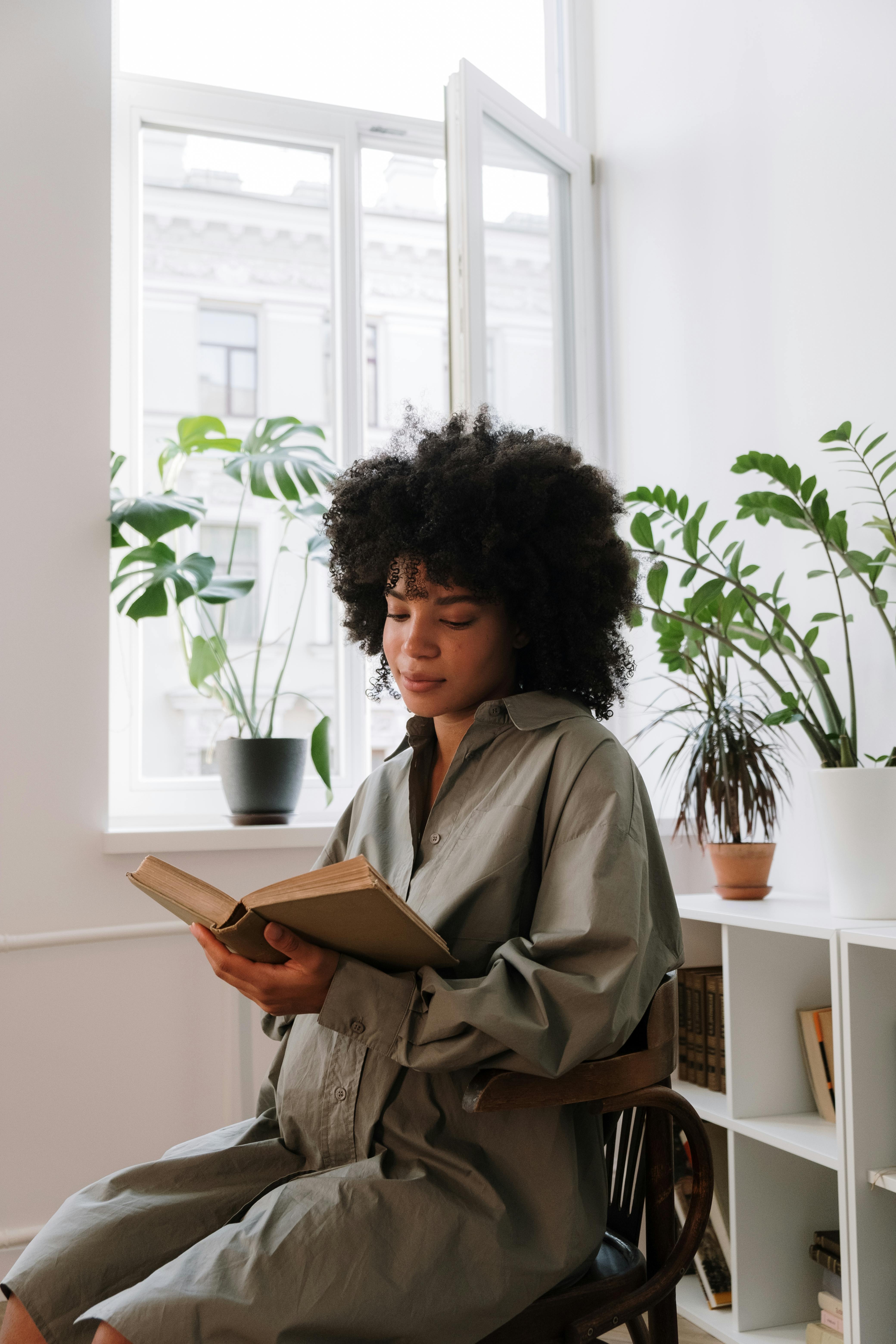 woman in brown coat holding book