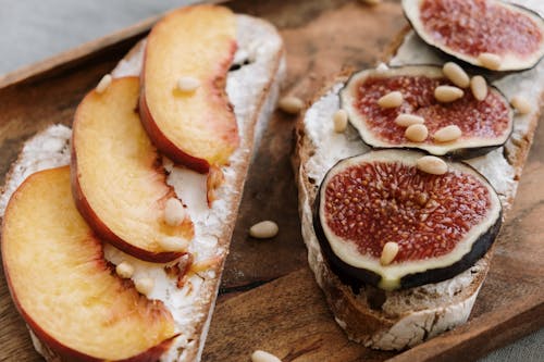 Free Fig and Peach Toasts with Feta Cheese on a Cutting Board Stock Photo