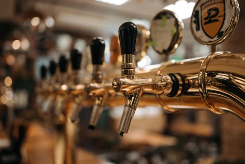 Free Shiny beer taps in a bar with a warm, inviting atmosphere. Stock Photo