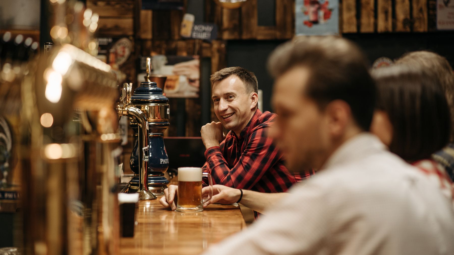 A cheerful group enjoying drinks at a cozy pub bar, capturing leisure and social vibes.