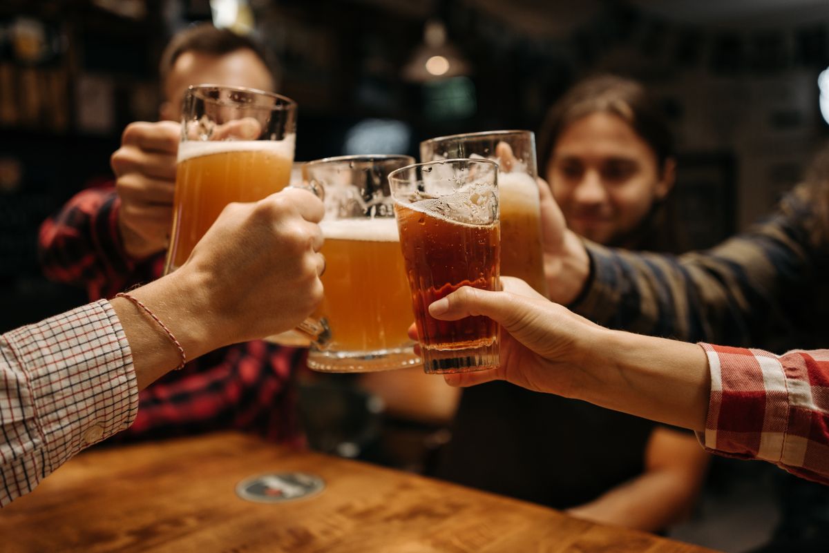 A group of friends celebrating with beer mugs indoors