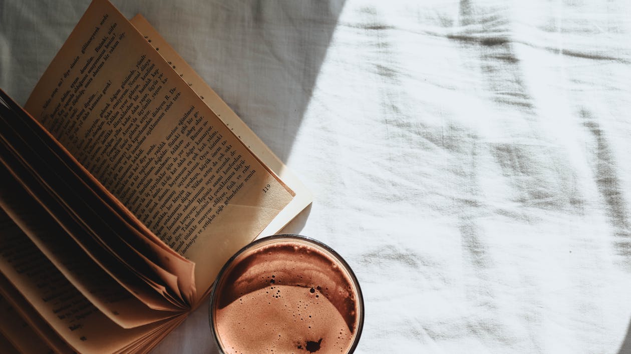 Free Book with Yellowing Pages and a Coffee in Bed  Stock Photo