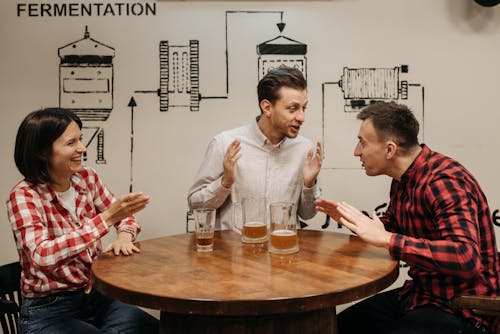 Friends Talking at a Table with Glasses of Beer