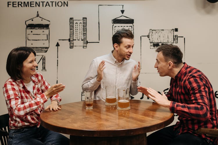 Friends Talking At A Table With Glasses Of Beer