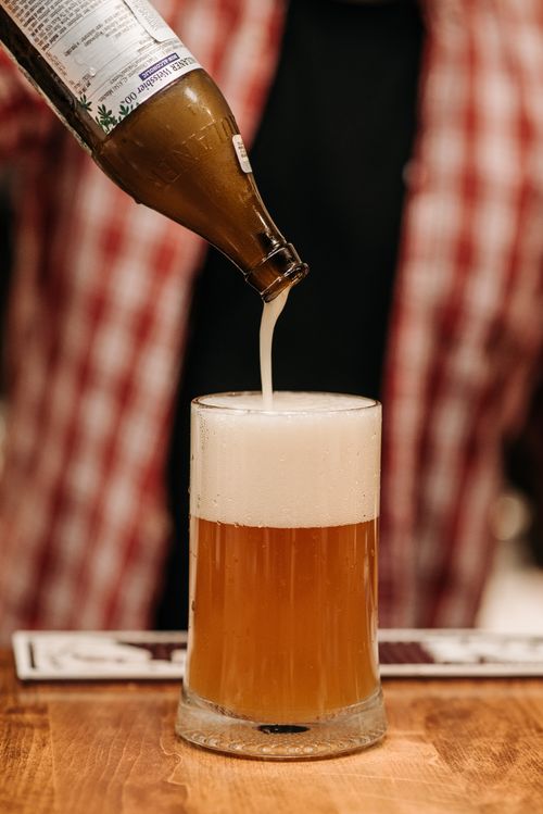 Free Close-up shot of a beer being poured into a glass with a rich foamy head. Stock Photo