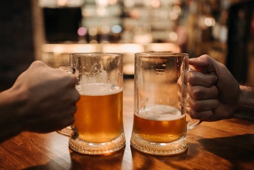 People Holding Glasses of Beer