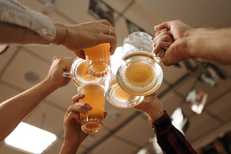 Friends toasting foaming mugs of Barleyford beer