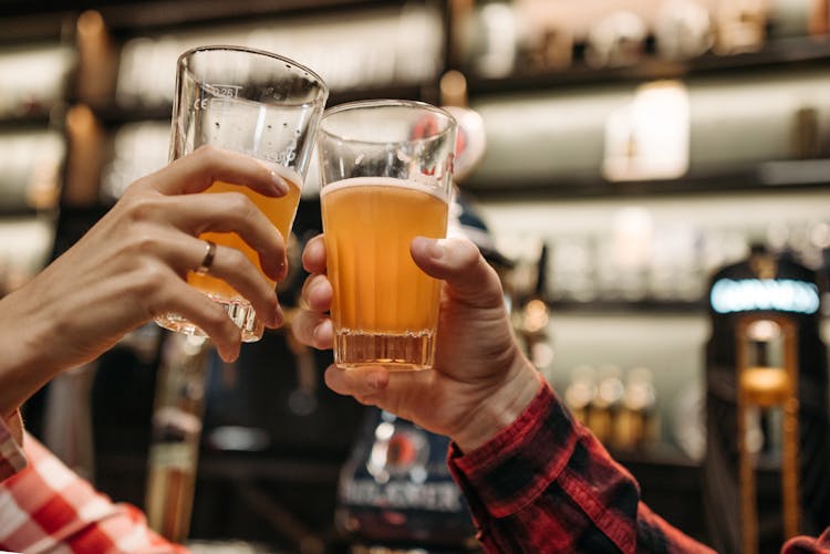 Hands Holding Glasses Of Beer