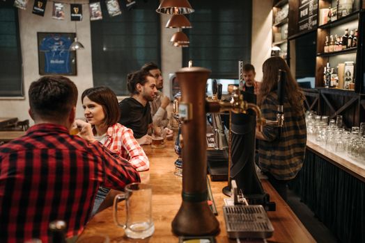 Friends having a relaxed conversation over drinks at a warm and inviting bar setting.