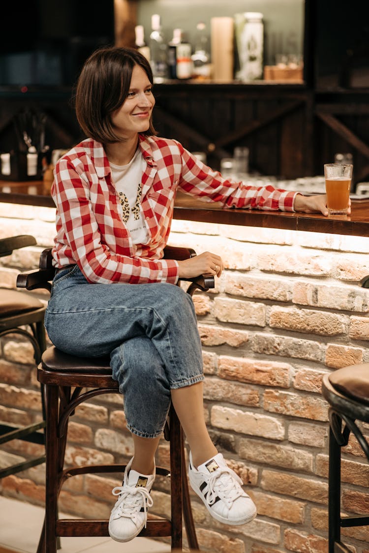 A Woman In  Red Long Sleeve Shirt Sitting On A Chair