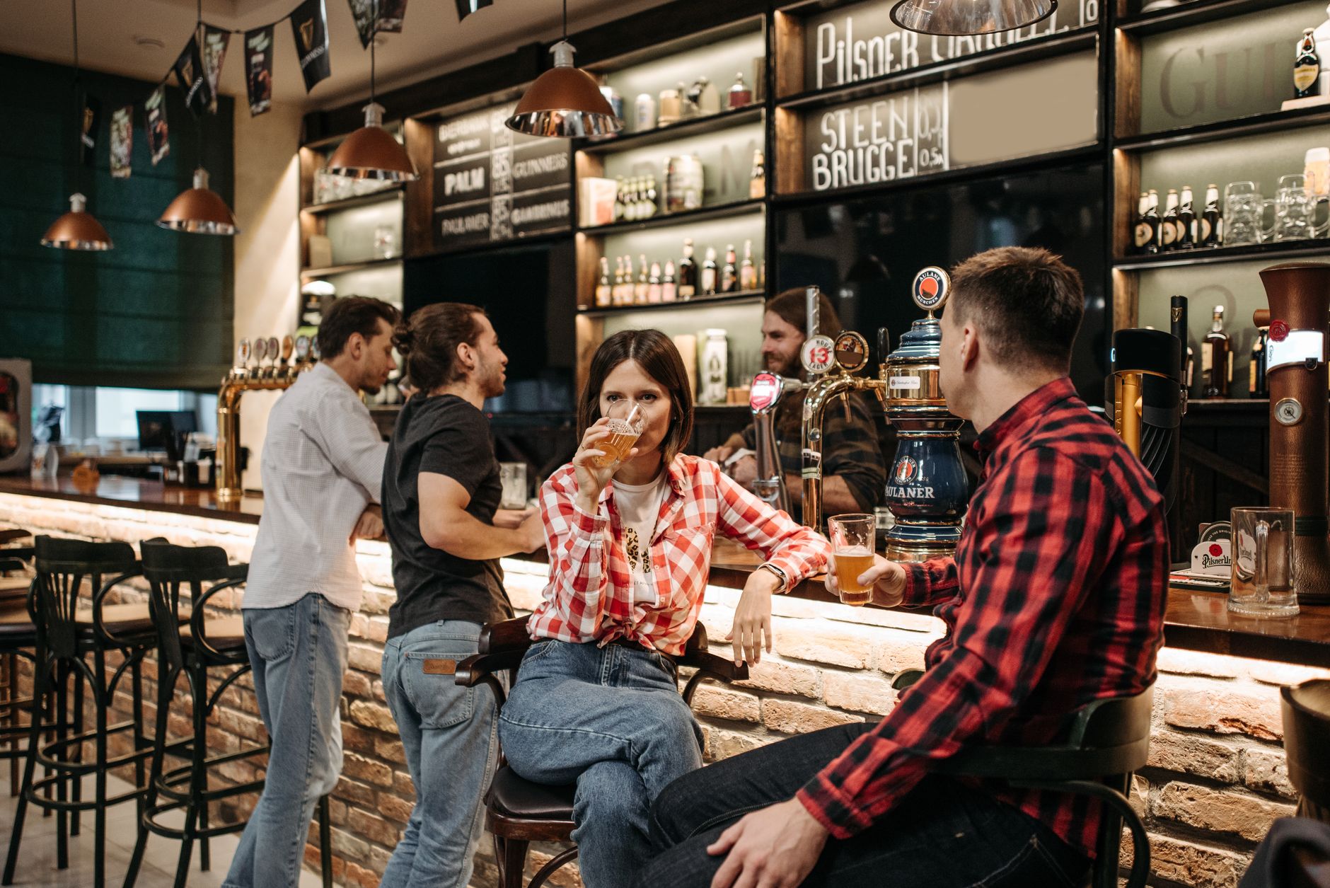Mates crowding a pub bar on a busy night, the sort of room that can still hide softer drink sales.