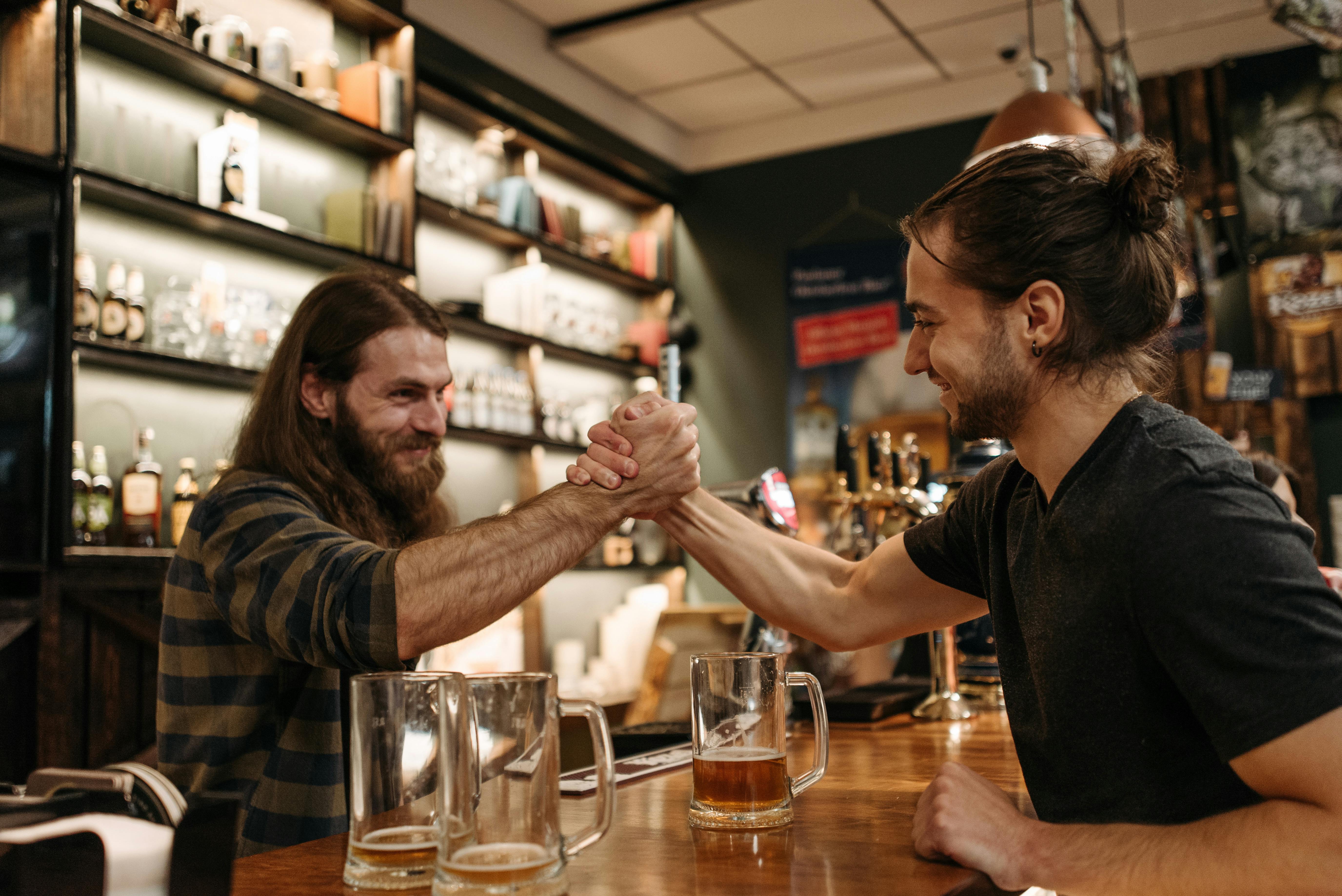 Two Men Arm Wrestling in the Bar · Free Stock Photo