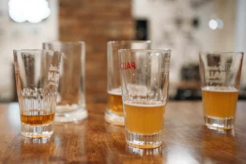 Free Close-Up Shot of Glasses of Beer on a Wooden Table Stock Photo